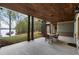 Covered patio with wood ceiling, stone pillars, and serene lake views at 7305 Breeze Bay Rd, Cumming, GA 30041