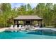 Inviting pool house featuring an outdoor bar, comfortable seating, and a shaded area for relaxation and entertainment at 7305 Breeze Bay Rd, Cumming, GA 30041
