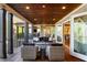 Covered porch with wood ceiling features wicker seating and an open view from interior at 7305 Breeze Bay Rd, Cumming, GA 30041