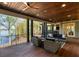 Spacious covered porch features wood floors, wicker seating, and beautiful lake views at 7305 Breeze Bay Rd, Cumming, GA 30041