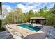 Stunning backyard oasis featuring a sparkling pool, sun loungers, and a stylish pool house for ultimate relaxation at 7305 Breeze Bay Rd, Cumming, GA 30041
