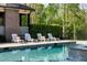 Relaxing poolside scene featuring a refreshing pool, comfortable loungers, and lush landscaping for privacy at 7305 Breeze Bay Rd, Cumming, GA 30041