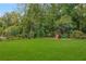 Landscaped backyard with an open lawn and a wooden playset and slide at 808 Lullwater Ne Rd, Atlanta, GA 30307