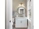 Charming bathroom with a white vanity, marble countertop, and a round mirror reflects the natural light from the window at 808 Lullwater Ne Rd, Atlanta, GA 30307