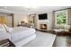 Bright primary bedroom with fireplace, seating area, light hardwood flooring, and multiple windows at 808 Lullwater Ne Rd, Atlanta, GA 30307