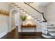 Bright foyer with hardwood floors, staircase with black and white banister, and arched doorway at 808 Lullwater Ne Rd, Atlanta, GA 30307