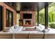 Inviting outdoor living area with a brick fireplace, comfortable seating, and a lush backyard view at 808 Lullwater Ne Rd, Atlanta, GA 30307