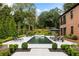 A stunning pool area features lounge chairs, impeccable landscaping, and a beautiful brick home in the background at 808 Lullwater Ne Rd, Atlanta, GA 30307