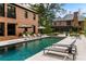 A luxurious in-ground pool with lounge chairs sits between the main house and the guest house at 808 Lullwater Ne Rd, Atlanta, GA 30307