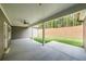A covered back porch with concrete flooring and a ceiling fan overlooks the verdant backyard at 82 Lexie Court, Rockmart, GA 30153