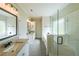 Bathroom featuring dual vanities with granite counters, a large mirror, and a glass shower at 82 Lexie Court, Rockmart, GA 30153