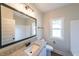 The full bathroom boasts a granite countertop, a big mirror, tub with shower, and a window at 82 Lexie Court, Rockmart, GA 30153