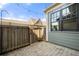 Private backyard patio features a charming fence, stone pavers, and string lights for outdoor entertaining at 118 Brighton Blvd, Woodstock, GA 30188