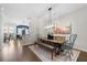 Open concept dining area with rustic wooden table, stylish light fixture, and wood floors at 118 Brighton Blvd, Woodstock, GA 30188