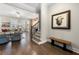Welcoming entryway featuring hardwood floors, staircase, and a charming bench with decorative art piece at 118 Brighton Blvd, Woodstock, GA 30188