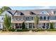 Street view of new townhomes with manicured lawns, elegant landscaping, and covered porches at 118 Brighton Blvd, Woodstock, GA 30188