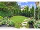 Professionally landscaped backyard with lush greenery, stone pathway, and decorative mulch at 134 Lakestone Pkwy, Woodstock, GA 30188