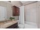 Bathroom featuring granite countertops, tile shower, and dark wood cabinets at 134 Lakestone Pkwy, Woodstock, GA 30188