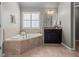 Relaxing bathroom featuring a soaking tub, vanity, and natural light at 134 Lakestone Pkwy, Woodstock, GA 30188