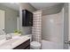 Bathroom featuring tub with shower, dark vanity, toilet, mirror, and neutral color palette at 134 Lakestone Pkwy, Woodstock, GA 30188