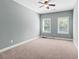 This bedroom offers two windows with blinds and neutral carpeting and paint at 134 Lakestone Pkwy, Woodstock, GA 30188