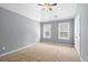 This bedroom features a ceiling fan, and neutral carpet and paint, and windows with blinds at 134 Lakestone Pkwy, Woodstock, GA 30188