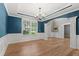 Formal dining room featuring hardwood floors, wainscoting, decorative lighting, and large window with wooded views at 134 Lakestone Pkwy, Woodstock, GA 30188
