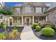 Charming two-story home featuring a stone facade, covered porch, and professionally landscaped front yard at 134 Lakestone Pkwy, Woodstock, GA 30188