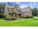 Charming two-story home with a combination of stone and siding, complemented by a well-manicured lawn and inviting landscaping at 134 Lakestone Pkwy, Woodstock, GA 30188