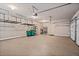 Spacious garage with epoxy flooring, overhead storage racks, and shelving units for organization at 134 Lakestone Pkwy, Woodstock, GA 30188