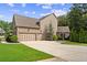 Spacious three-car garage with an extensive driveway, backyard basketball hoop, and lush greenery for a comfortable Gathering lifestyle at 134 Lakestone Pkwy, Woodstock, GA 30188