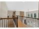 Second story hallway with wood railing overlooking living room with stone fireplace and large windows at 134 Lakestone Pkwy, Woodstock, GA 30188