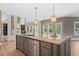 Open concept: kitchen island with granite counters next to living room with stone fireplace and large windows at 134 Lakestone Pkwy, Woodstock, GA 30188
