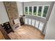 Living room with floor-to-ceiling stone fireplace, large windows, hardwood floors and modern lighting at 134 Lakestone Pkwy, Woodstock, GA 30188