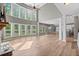 Spacious living room with hardwood floors, soaring ceilings, and a wall of windows providing ample natural light at 134 Lakestone Pkwy, Woodstock, GA 30188