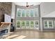Open-concept living room with fireplace, hardwood floors, and large windows overlooking a lush backyard at 134 Lakestone Pkwy, Woodstock, GA 30188