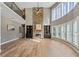 Expansive living room showcasing hardwood floors, soaring ceilings, a stone fireplace, and scenic backyard views at 134 Lakestone Pkwy, Woodstock, GA 30188