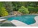 Inviting backyard pool with a waterfall feature and lush greenery, creating a private oasis at 134 Lakestone Pkwy, Woodstock, GA 30188
