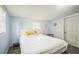 Serene bedroom with pale blue walls, two windows, and a white headboard bed, creating a peaceful retreat at 3251 Auburn Ave, Dacula, GA 30019