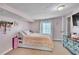 Bright bedroom showcasing a bed with soft pink cover, a textured ceiling, and a vintage cabinet at 3251 Auburn Ave, Dacula, GA 30019