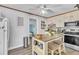 Cozy kitchen with stainless steel appliances, an island, a ceiling fan, and custom shelving for easy organization at 3251 Auburn Ave, Dacula, GA 30019