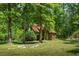 Charming log cabin with red roof surrounded by lush trees in a peaceful, wooded setting at 4728 Corn Creek Drive, Fairburn, GA 30213