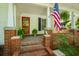 Inviting front porch with brick steps, columns, and lush, green plants at 4728 Corn Creek Drive, Fairburn, GA 30213
