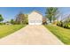 Long paved driveway leading to a 2-car garage, surrounded by green grass and blue skies at 15 Cobblestone Ct, Douglasville, GA 30134