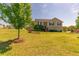 Inviting two-story home showcasing a well-kept lawn, mature trees, stone facade, and detached garage providing ample space at 15 Cobblestone Ct, Douglasville, GA 30134