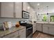 Bright kitchen with granite countertops, stainless steel appliances, and modern backsplash at 1744 Habershal Nw Rd, Atlanta, GA 30318