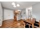 An open dining area features hardwood floors, a modern chandelier, and a view into the kitchen at 4413 Pinscher St, Union City, GA 30291