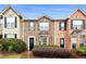 Beautiful townhome showcasing a brick facade, complemented by manicured landscaping and symmetrical shuttered windows at 4413 Pinscher St, Union City, GA 30291