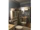 A full bath with a tub, shower, sliding glass doors, toilet, and decorative shelving for all your bathroom essentials at 3546 Mount Vernon Ct, Lawrenceville, GA 30044
