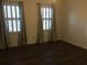 A bright bedroom featuring dark wood floors, neutral walls, and windows that let in natural light at 3546 Mount Vernon Ct, Lawrenceville, GA 30044